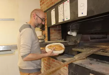 Le boulanger face au “Voisin”, son four à bois. Avant cuisson, les pains sont striés de façon à évacuer leurs gaz.