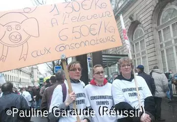 Lors de la manifestation des producteurs de porcs le 26 janvier à Paris, près de l'Assemblée nationale, des manifestantes portaient des T-Shirts "Consommateurs trompés" et une pancarte dénonçant les différences entre prix de production et prix de vente aux consommateurs.