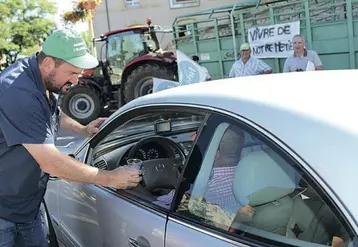 Olivier Boulat, président de la FDSEA distribue des verres de lait aux automobilistes lors de la manifestation.