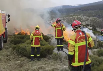 Des pompiers surveillent un début d'écobuage sur une parcelle agricole.