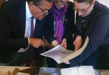 Trois personnes observent un document