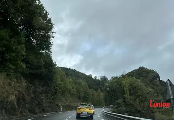 Voiture jaune sur une route à l'approche d'un virage