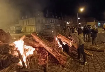 Des agriculteurs allument un feu avec des troncs d'arbres au rond-point Régemortes à Moulins.