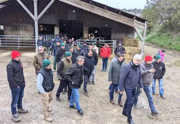 Un groupe d'homme marchant devant un bâtiment d'élevage sous la neige