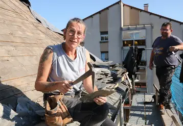 Une femme avec un marteau avec un homme sur sa gauche