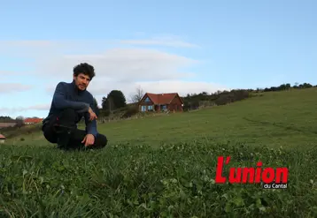Un homme accroupi au milieu de l'herbe. 
