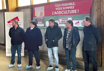 Un groupe est debout devant des affiches électorales agricoles