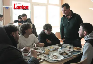 Un produicteur et des élèves en train de manger autour d'une table.