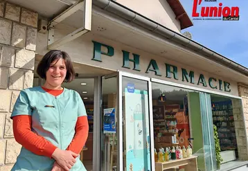 Une pharmacienne, devant sa pharmacie. 