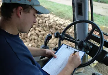 jeune salarié d'EDT au volant d'un engin agricole remplit un formulaire.