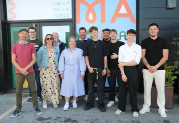 Onze personnes hommes, femmes, posant devant la devanture d'un futur restaurant.