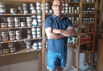 un homme dans sa boutique devant ses produits