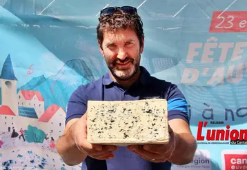 Nicolas Cussac tient dans ses mains une demi fourme de bleu d'Auvergne