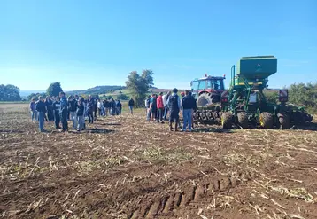 Elèves et adhérents de Cuma devant un tracteur et semoir semis-direct 6 m équipés des systèmes GPS, autoguidage, Isobus.