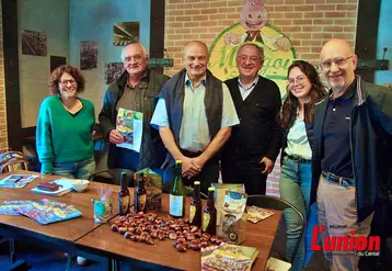 Un groupe de personnes débout, devant une table remplie de produits à la châtaigne. 
