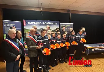 Les élus en écharpes tricolores entourent les jeunes sapeurs-pompiers avec leurs casques à a main.