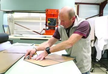 Un homme en train de découper du cuir.
