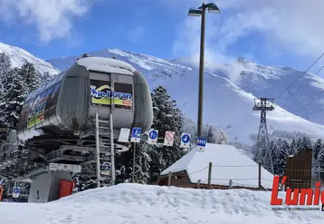 un télésiège avec la montagne enniegée en arrière plan. 