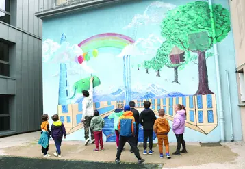 Des enfants regardent une fresque sur un mur.