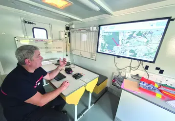 Un sapeur-pompier devant une carte du Cantal.
