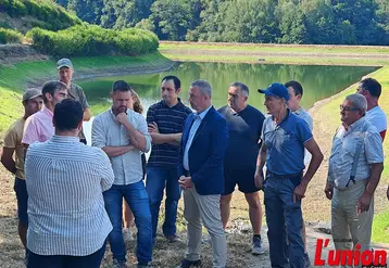 groupe de personnes devant une retenue collinaire d'eau