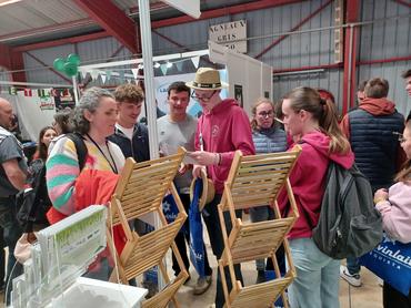 Des jeunes échangent avec une exposante sur un stand.