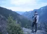 Un chasseur observe une vallée un fusil sur l'épaule.