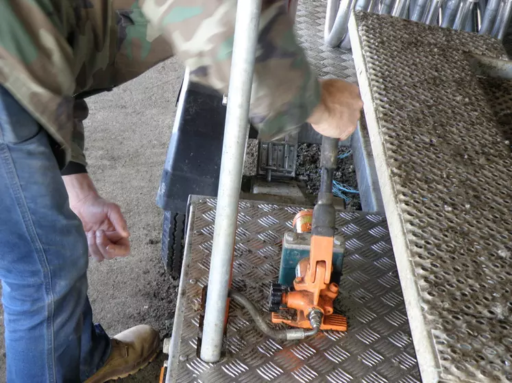 OPTIONChristophe actionne la poignée de l’une des pompes, pour permettre au vérin gauche de relever le côté gauche du plateau de sa remorque à Combi Clamp. © J.-F. Rivière