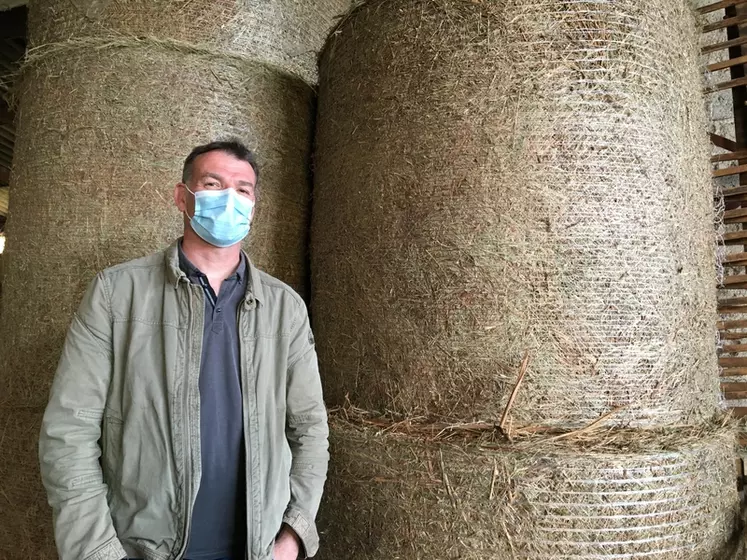 Laurent Etchebarne, du Gaec Etchank, cherchait un robot qui puisse couper et pailler de la fougère. Les boules de fougères sont en arrière-plan. © A. Dazet