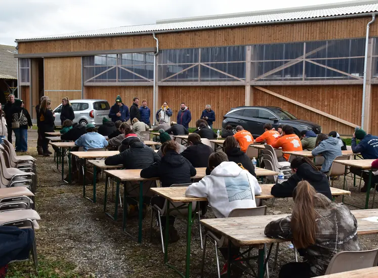 Des participants aux Ovinpiades répondent à un test écrit, assis dehors