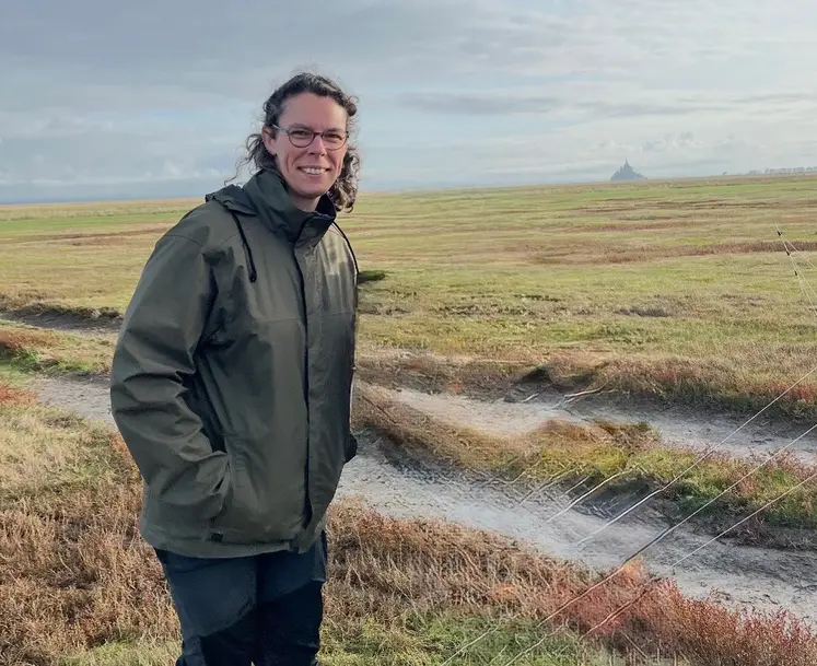 Une éleveuse se tient devant le Mont-Saint-Michel