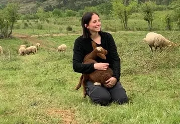 L'éleveuse Elise Boulbes avec un agneau dans les bras.