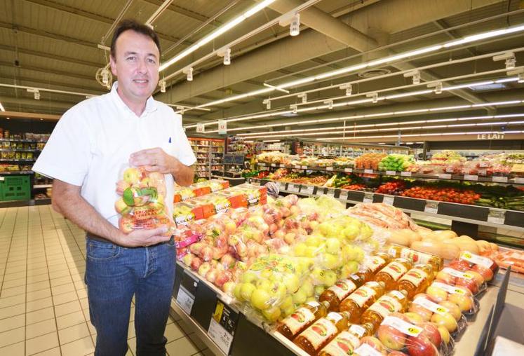 Thierry Bonnet, patron du Super U de Blaye-les-Mines, pose ici avec des pommes des Vergers de Trébas, une des références de produits locaux qu’il propose dans ses rayons.