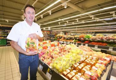 Thierry Bonnet, patron du Super U de Blaye-les-Mines, pose ici avec des pommes des Vergers de Trébas, une des références de produits locaux qu’il propose dans ses rayons.