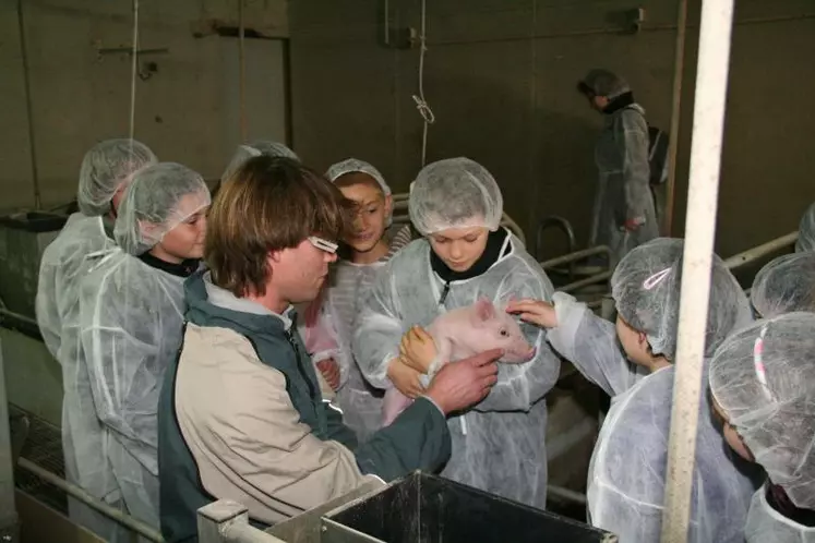 David Riou, éleveur et président de la commission communication de l'UGPVB, fait visiter un élevage de porcs aux enfants de l'école de Trémeur, dans les Côtes d'Armor.