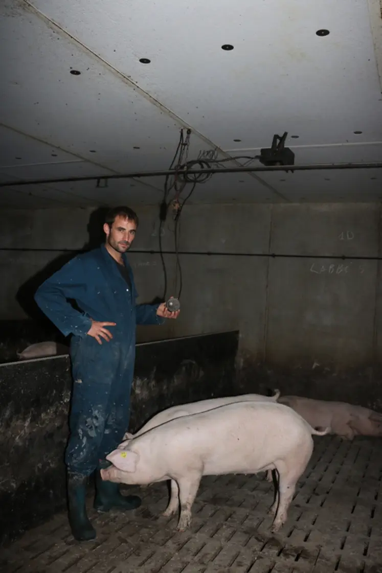 <em class="placeholder">Melaine Le Goff, salarié de l'élevage,  tient l'un des capteurs d'ambiance. Au plafond, la caméra infrarouge capte les images jour et nuit.</em>