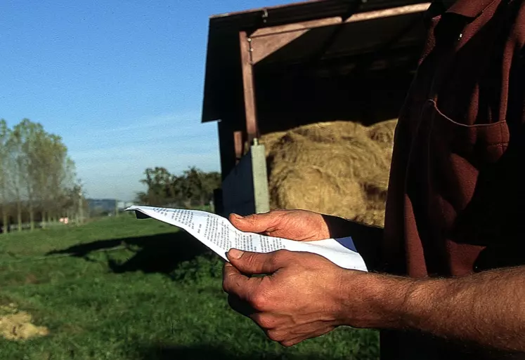 Agriculteur lisant un document.