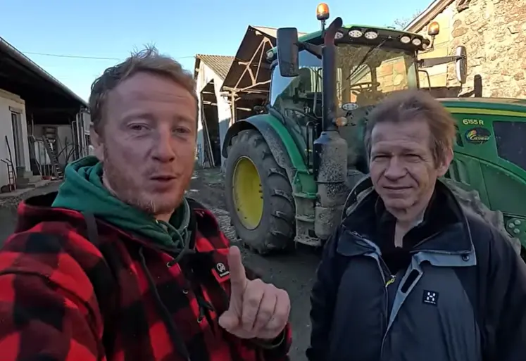 Etienne Fourmont et Jean-Marc Jancovici devant un tracteur dans une cour de ferme.