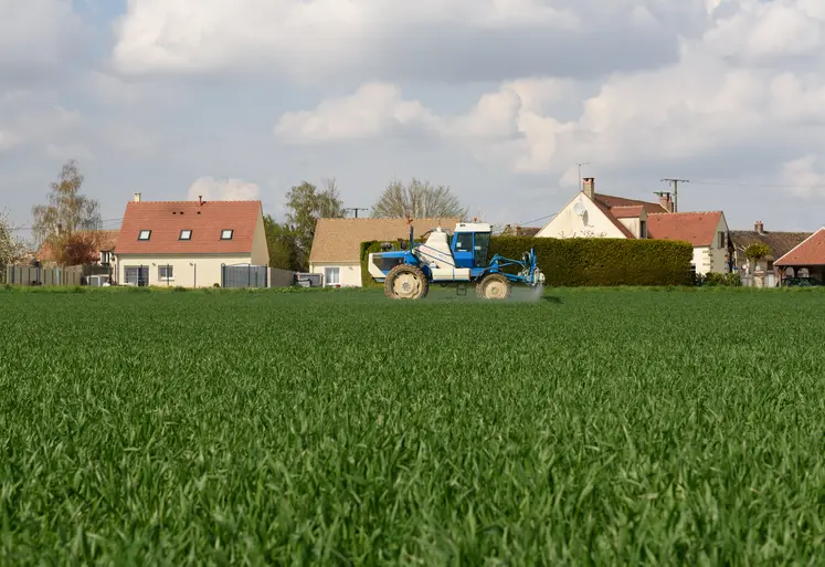 Pulvérisateur devant des maisons.