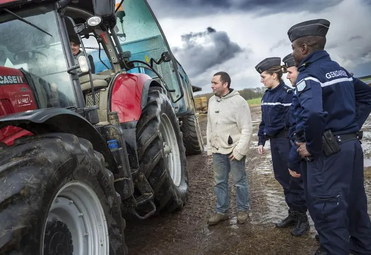 Gendarmes discutant avec un agriculteur devant un tracteur