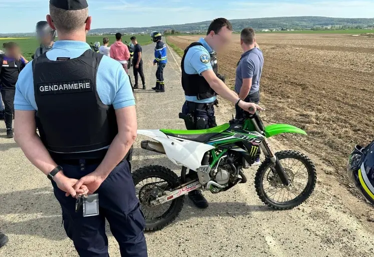 Gendarmes interpellant des jeunes pratiquant un rodéo sauvage à moto cross dans un champ