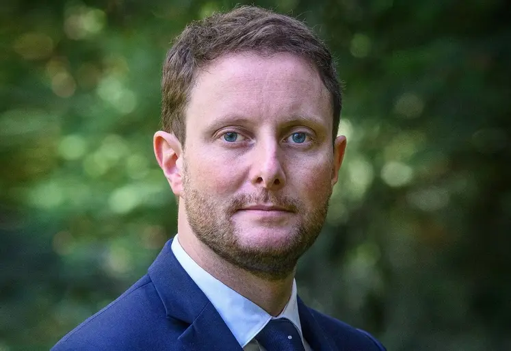 Clément Beaune, Haut-Commissaire à la stratégie et au plan, en gros plan devant un fond de verdure.
