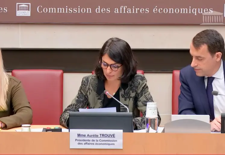 trois personnes assises devant un micro