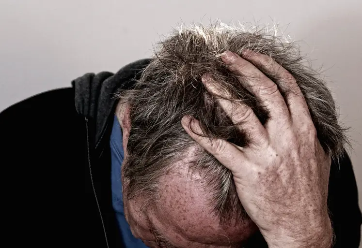 homme en détresse se tenant la tête dans les mains