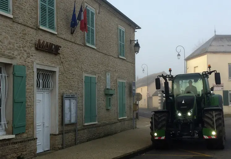 tracteur passant devant une mairie dans un village
