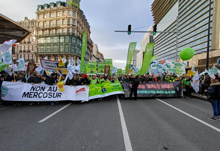 Des agriculteurs manifestant avec des banderoles contre l'accord UE-Mercosur dans les rues de Bruxelles