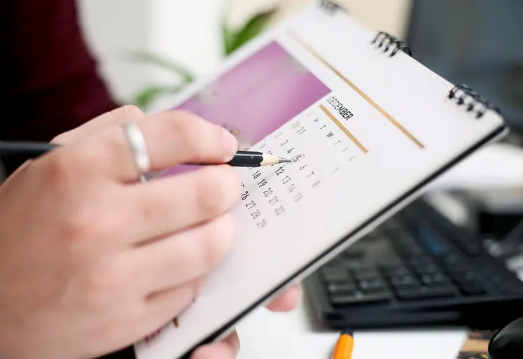 Une personne entoure la date d'un calendrier