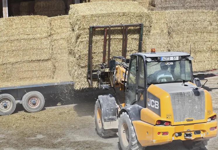 tracteur chargeant des bottes de paille