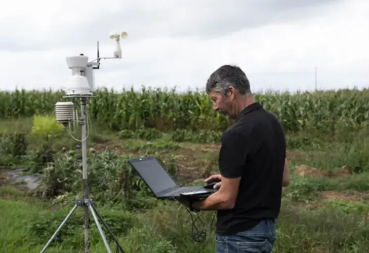 homme tenant un ordinateur dans un champ