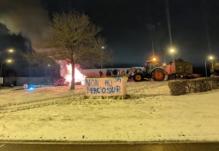 Tracteurs sur un rond point, avec un feu, et une banderole "non au Mercosur"